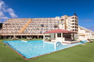 a large hotel with a swimming pool and a large building at Las Mareas Sea View Terrace 3 min to Beach in Morro del Jable