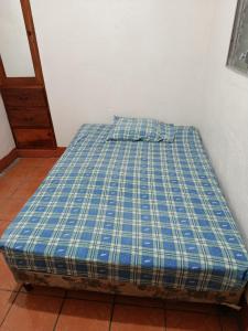 a bed in a room with a blue and white at Hostal Expansion in San Juan del Sur