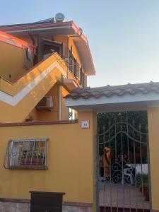 a yellow house with a gate and a fence at Nenniri's house in Villamassargia