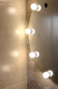 a bathroom with a group of lights on a mirror at Naša Priča Silver Lake in Veliko Gradište +33 photos