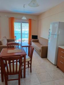 a kitchen and living room with a table and a refrigerator at Armonia Nakas in Yénion