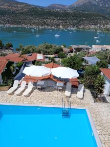 a pool with umbrellas and a view of the water at Armonia Nakas in Yénion
