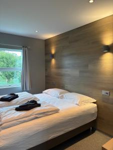 ein Schlafzimmer mit zwei Betten und einem großen Holzkopfteil in der Unterkunft Dalakot Búdardal in Búðardalur
