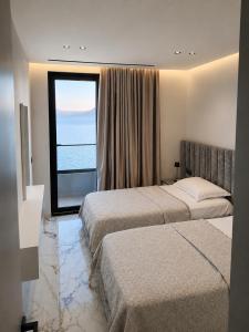 a hotel room with two beds and a large window at IDeal Sea View Apartment in Vlorë