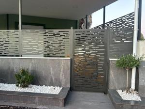 a fence in front of a house with two plants at Elia Apartments in Eretria
