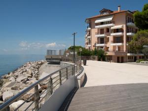 a walkway next to a building next to the water at Condominio Fortino in Grado