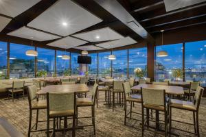 a restaurant with tables and chairs and large windows at Best Western PLUS City Centre Inn in Edmonton