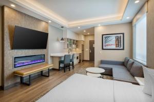 a living room with a couch and a tv at Best Western PLUS City Centre Inn in Edmonton
