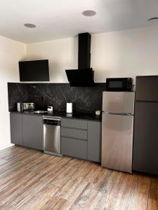 a kitchen with stainless steel appliances and wooden floors at La Muraza in Villaviciosa