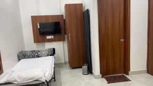 a room with a bed and a tv on a wall at Hotel 48 in Amritsar