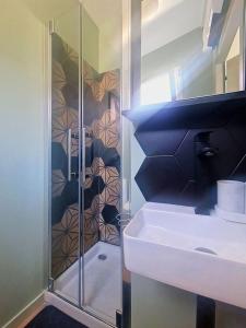a bathroom with a glass shower with a sink at Le Bourg - Studio 2pers -Climatisation et terrasse in Bourg-lès-Valence