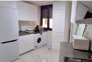 eine weiße Küche mit einer Waschmaschine darin in der Unterkunft Modern central flat in Ceuta