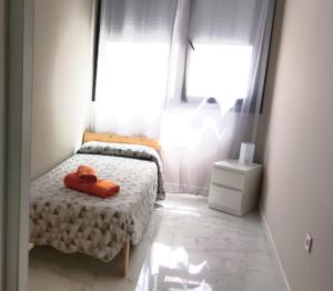 ein kleines Schlafzimmer mit einem Bett und einem Fenster in der Unterkunft Modern central flat in Ceuta