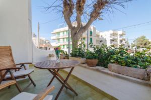 une table et des chaises sur un balcon avec un arbre dans l'établissement Son Homs, à Colonia Sant Jordi