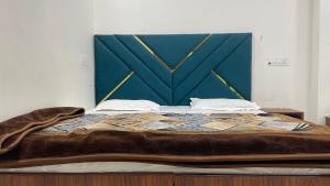a large bed with a blue headboard in a room at Hotel 48 in Amritsar
