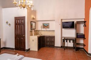 a living room with a television and a fireplace at Hotel Casa Antigua by AHS in Antigua Guatemala