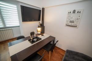 a room with a table with chairs and a television at M-Buf Center Apartament in Gura Humorului