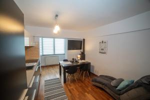 a living room with a table and a couch at M-Buf Center Apartament in Gura Humorului