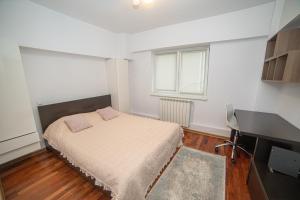 a small bedroom with a bed and a desk at M-Buf Center Apartament in Gura Humorului +7 photos