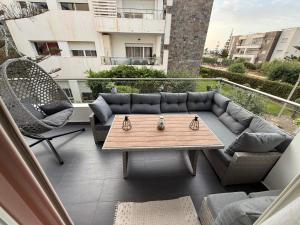 a patio with a couch and chairs on a balcony at Résidence Perla Saidia-seulement pour les familles- Plage à 5 min à pieds - Piscine en travaux in Saïdia