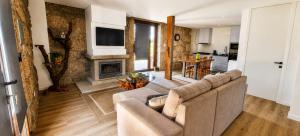 a living room with a couch and a fireplace at Serração House in Rio Caldo