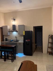 a kitchen with a black refrigerator and a table at Peaceful Studio Retreat Near Shoal Bay Beach in Shoal Bay Village