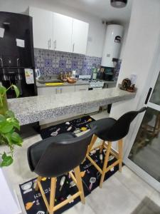 a kitchen with two chairs sitting under a counter at Departamento ÚNICO in Presidencia Roque Sáenz Peña
