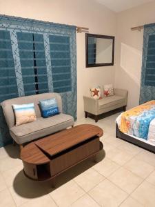 a room with a bed and a chair and a table at Peaceful Studio Retreat Near Shoal Bay Beach in Shoal Bay Village