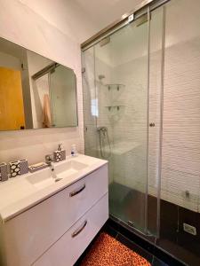 a bathroom with a sink and a glass shower at Atlas Ocean View Vue Mer Directe in Aourir +13 photos