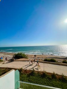 a group of people walking on a sidewalk near the beach at Atlas Ocean View Vue Mer Directe in Aourir