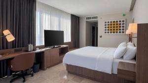a hotel room with a bed and a desk with a computer at Holiday Inn Acapulco Amarea by IHG in Acapulco