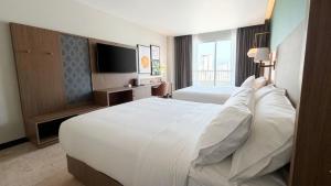 a hotel room with a large bed and a television at Holiday Inn Acapulco Amarea by IHG in Acapulco +61 photos