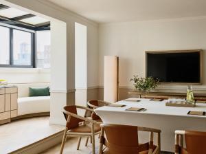a living room with a table and chairs and a tv at Kimpton Ashbel New York Park Avenue by IHG in New York