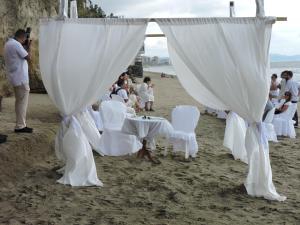 a group of people sitting around a table on the beach at Hotel Puerto Gaviota in Tonsupa