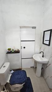 a bathroom with a toilet and a sink at Casa Vigia 1 Quarto in Vigia +8 photos