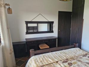 a bedroom with a dresser and a mirror on the wall at Villa Alejandra in Quebrada Vieja