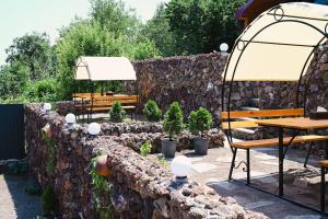 a garden with a stone wall and a table and bench at EKA Resort in Goris +11 photos