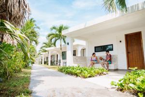 two people sitting on the porch of a house at Hotel Bungalows Marbella Costa Esmeralda in Monte Gordo