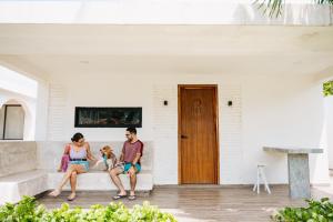 a man and a woman sitting on a couch with a dog at Hotel Bungalows Marbella Costa Esmeralda in Monte Gordo