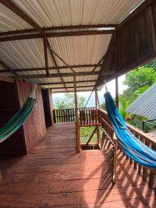 a porch with two hammocks on a wooden deck at Cumbilinchero Selva Mojada in Nuquí