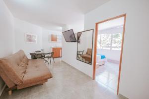 ein Wohnzimmer mit Sofa und Spiegel in der Unterkunft Apartamento Edificio Neon Centro in Ibagué