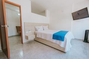 ein kleines Schlafzimmer mit einem Bett und einem Spiegel in der Unterkunft Apartamento Edificio Neon Centro in Ibagué