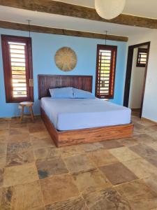 a bedroom with a large bed and blue walls at Casa Bea in Fortim