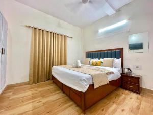 a bedroom with a large bed and a wooden floor at Land Chaster Kasauli in Kasauli