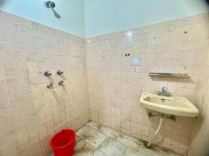 a bathroom with a sink and a red trash can at Land Chaster Kasauli in Kasauli