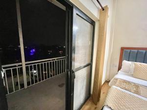 a room with a large window with a view of the city at Land Chaster Kasauli in Kasauli