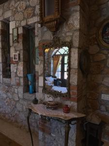 a stone room with a table and a mirror at Solomon&Sons in Dhërmi