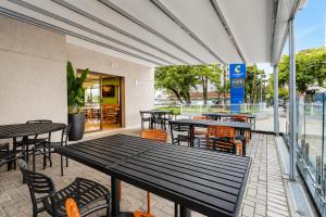 an empty patio with tables and chairs in a restaurant at Comfort Hotel Joinville in Joinville