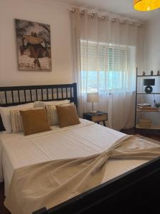 a bedroom with a large bed and a window at T2 central Valença in Valença