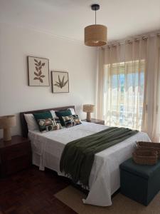 a bedroom with a large bed and a window at T2 central Valença in Valença
